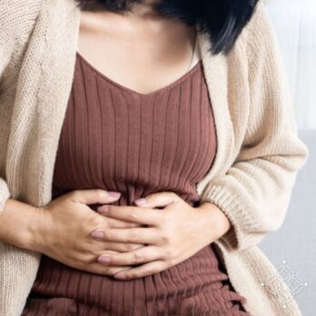 Mujer sosteniendo su viente por dolor intestinal