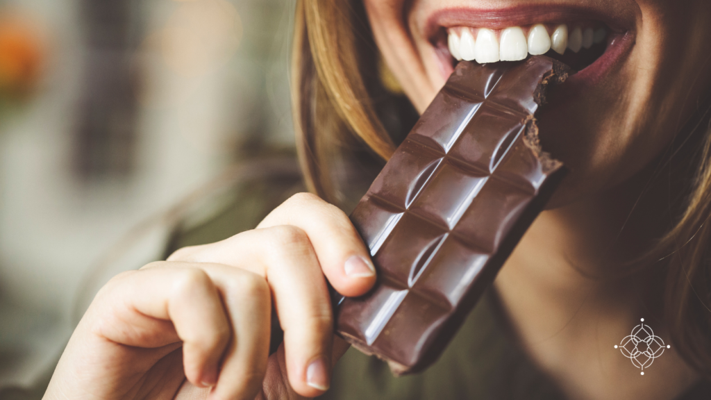 Una mujer comiendo una barra de chocolate y se relaja